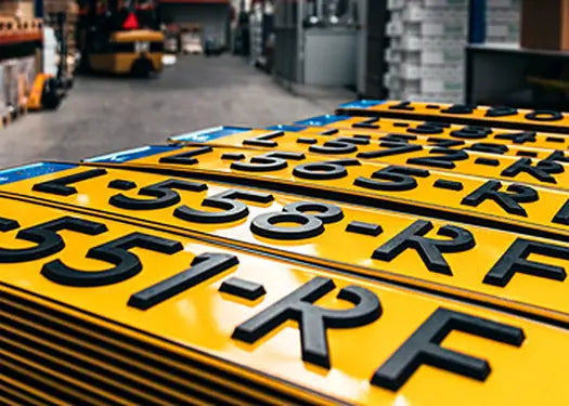Gele kentekenplaten met zwarte letters in onze fabriek
